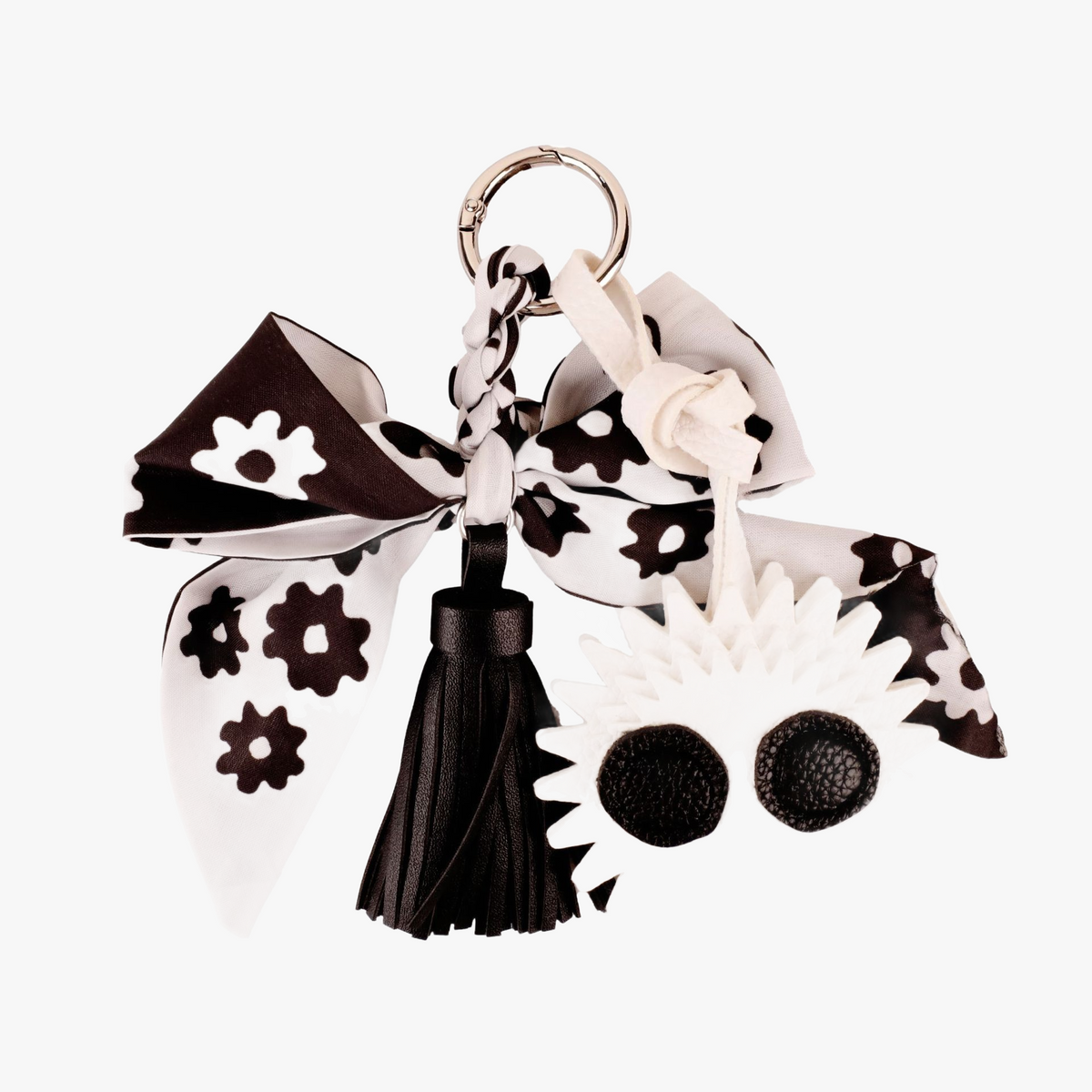 Black and white silk bow bag charm attached to a leather tote bag
