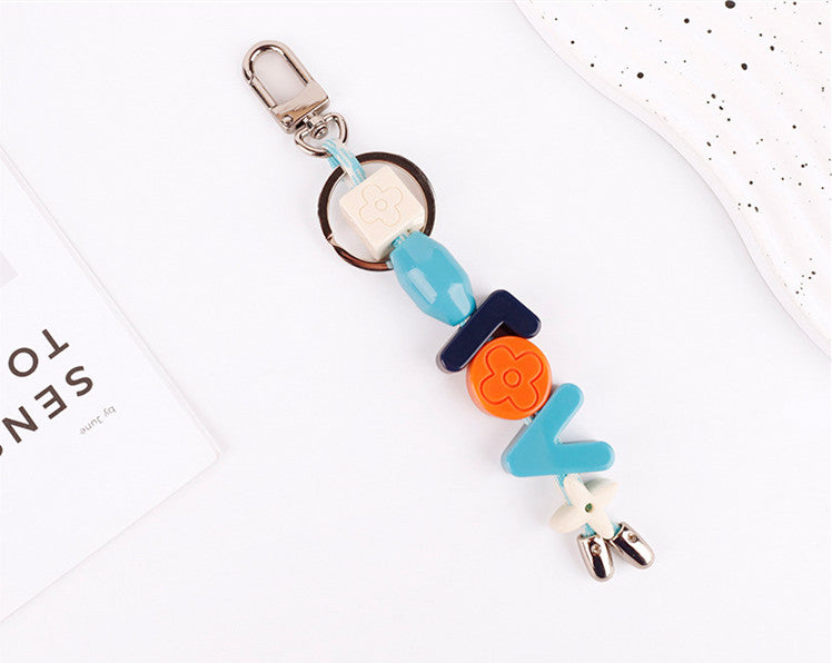 Pastel resin letter bag accent on leather shoulder bag
