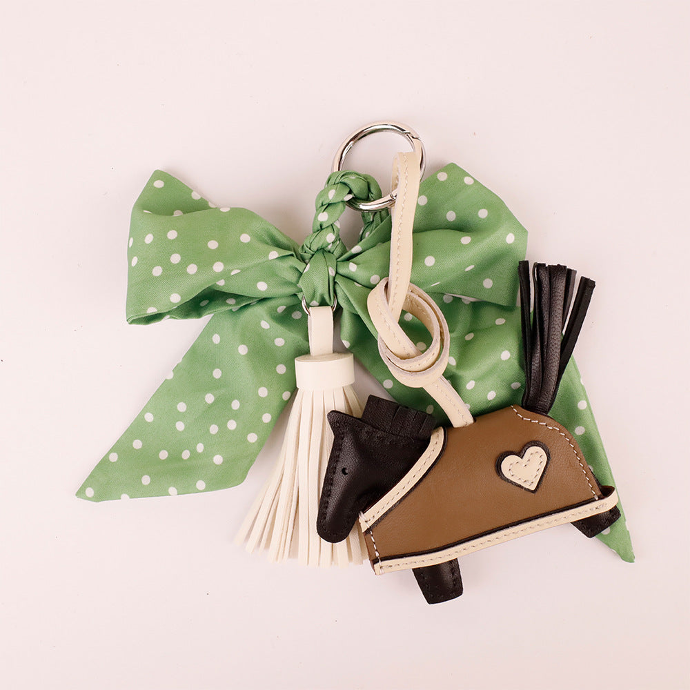 Unique green bow bag pendant clipped on a minimalist handbag