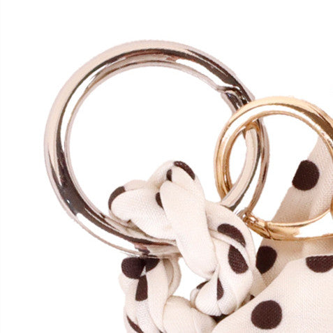 Monochromatic fabric bow ornament fastened to a women zipper wallet