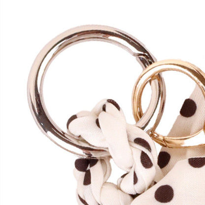Monochromatic fabric bow ornament fastened to a women zipper wallet
