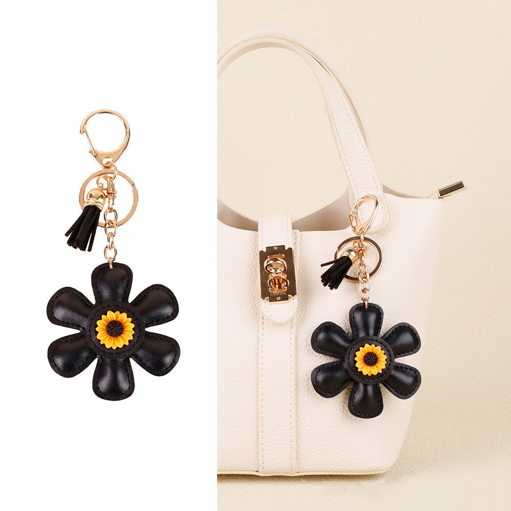 Yellow sunflower charm hanging beside a tote handle