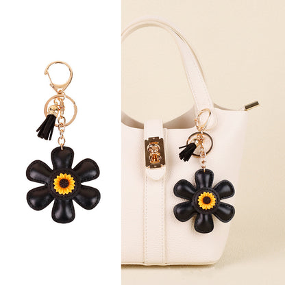 Yellow sunflower charm hanging beside a tote handle