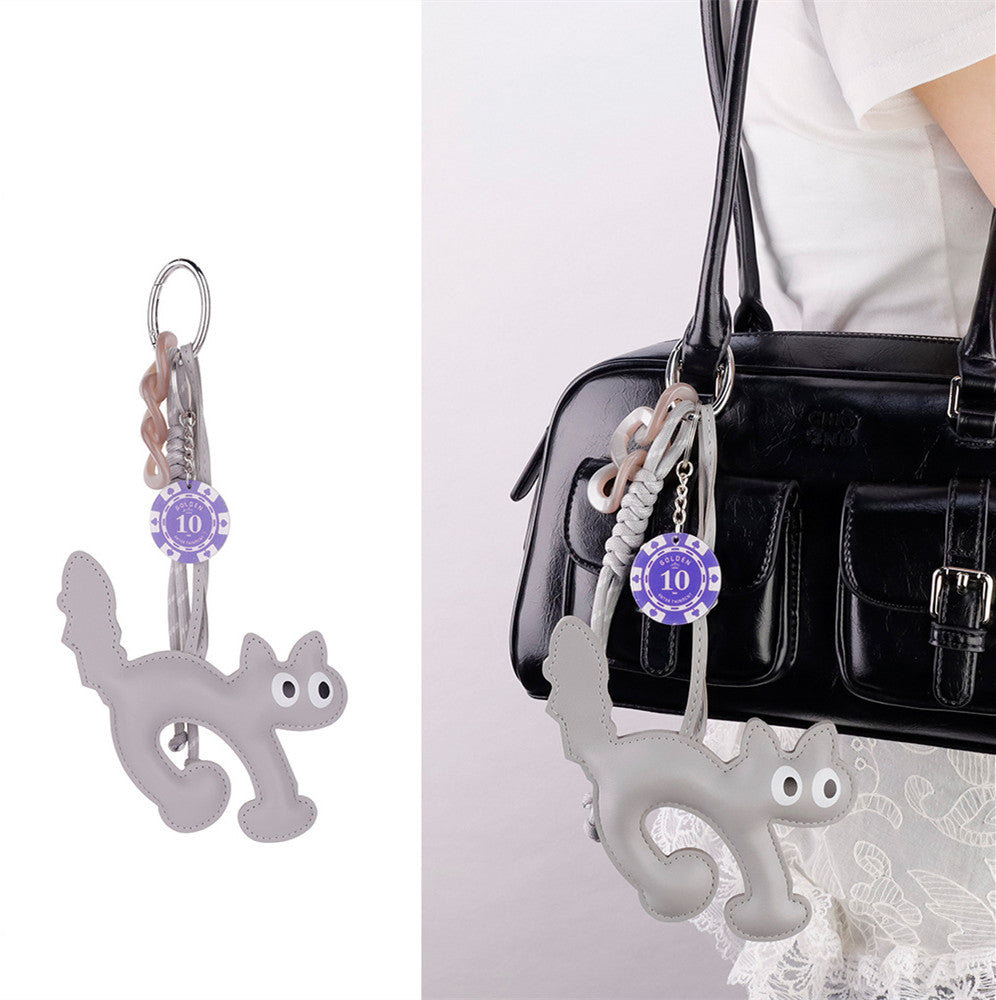 Quirky cat keyring decorating the front of a pastel summer tote bag