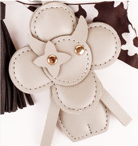 Handmade black bow charm with long tassel fringe on a luxury handbag