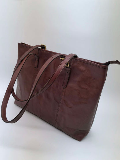 Structured leather carryall with a roomy base for notebooks and personal accessories.