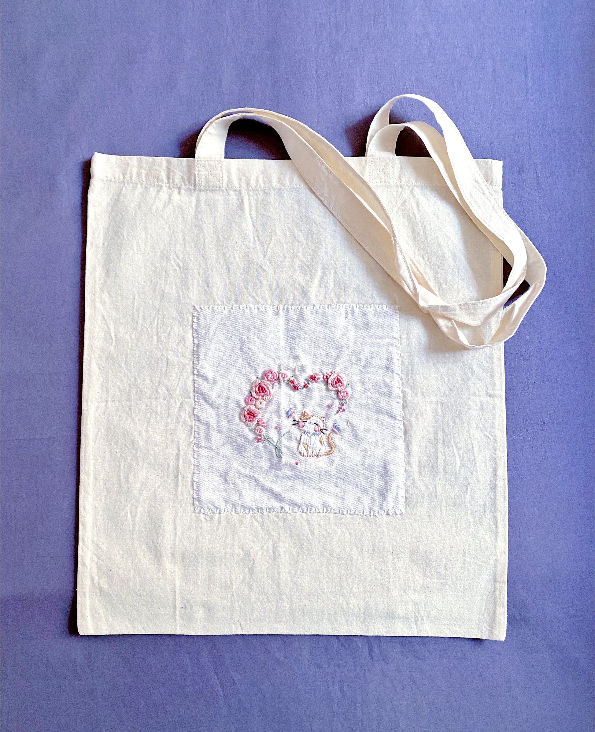 Ultra-light foldable travel tote with unique hand-embroidered art, holding essentials without weight.