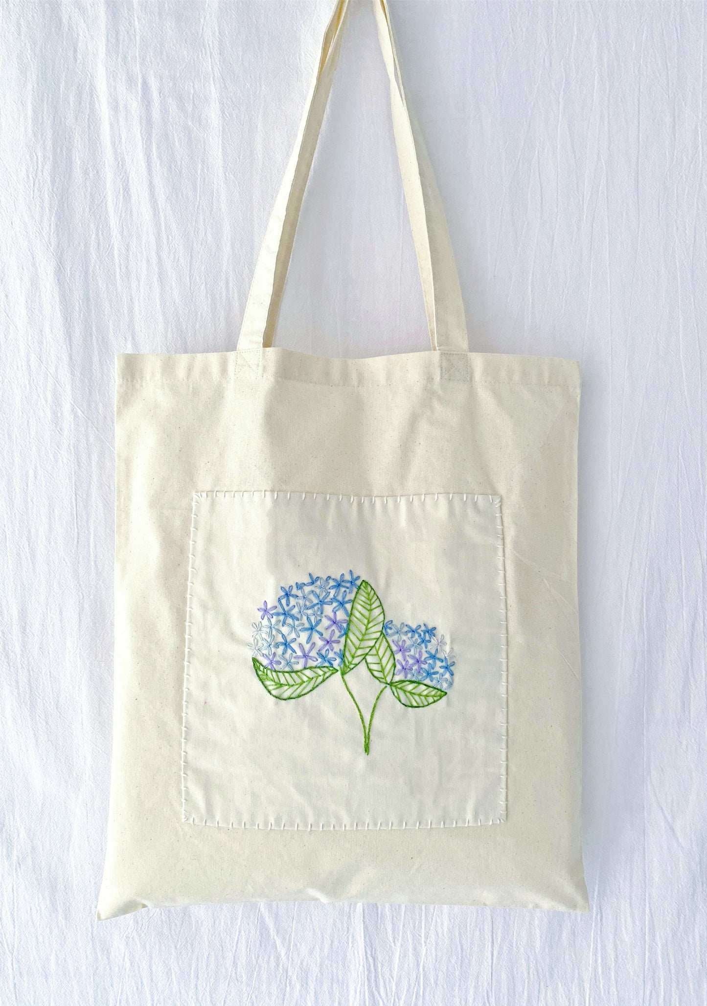 Carrying fresh greens in a soft cotton tote with hand-embroidered flowers makes zero-waste shopping feel elegant and personal.