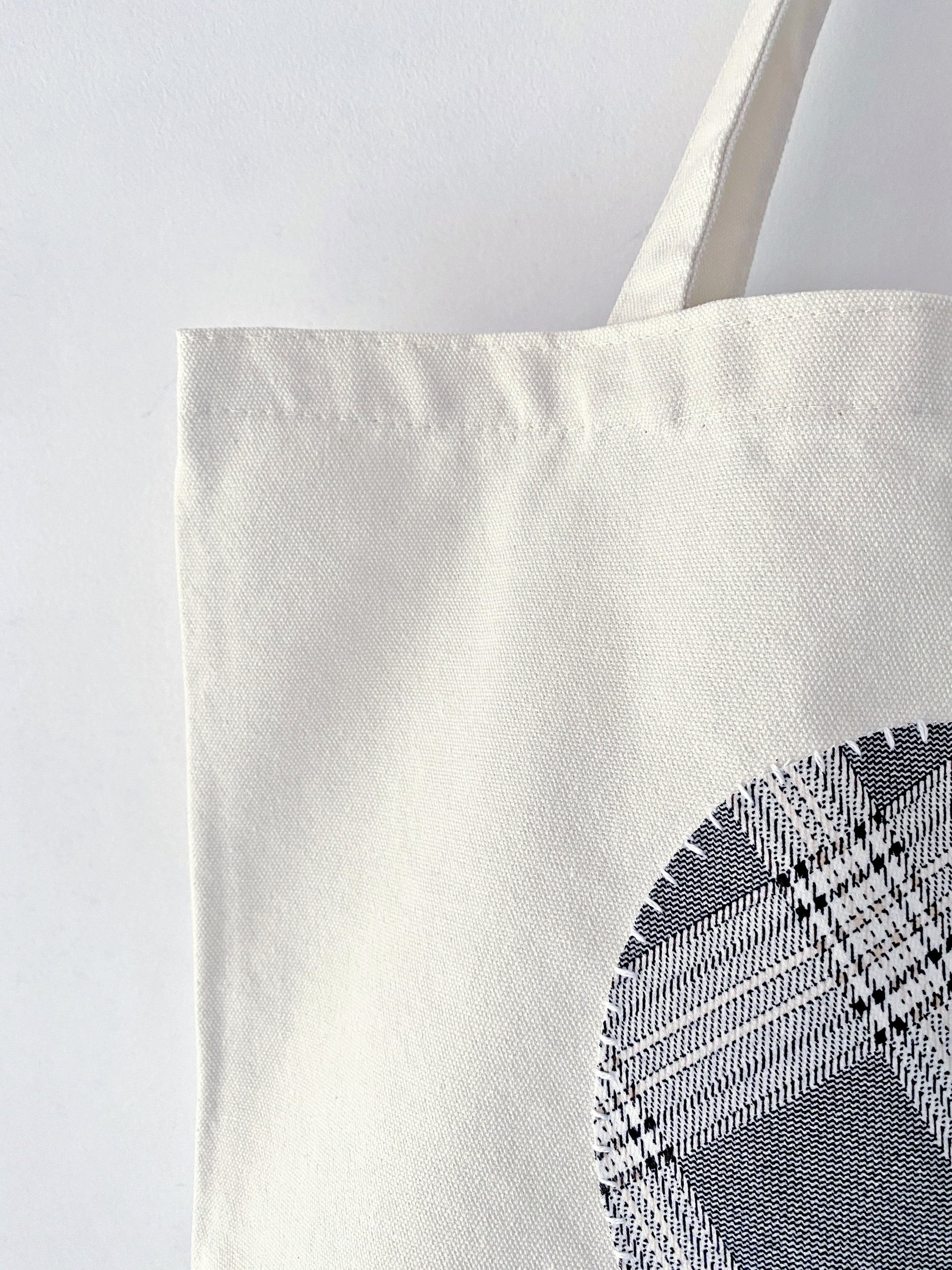 Heavy-duty natural canvas tote with folk-art stitching. A sturdy gift for mentors who appreciate timeless, sustainable handmade quality.