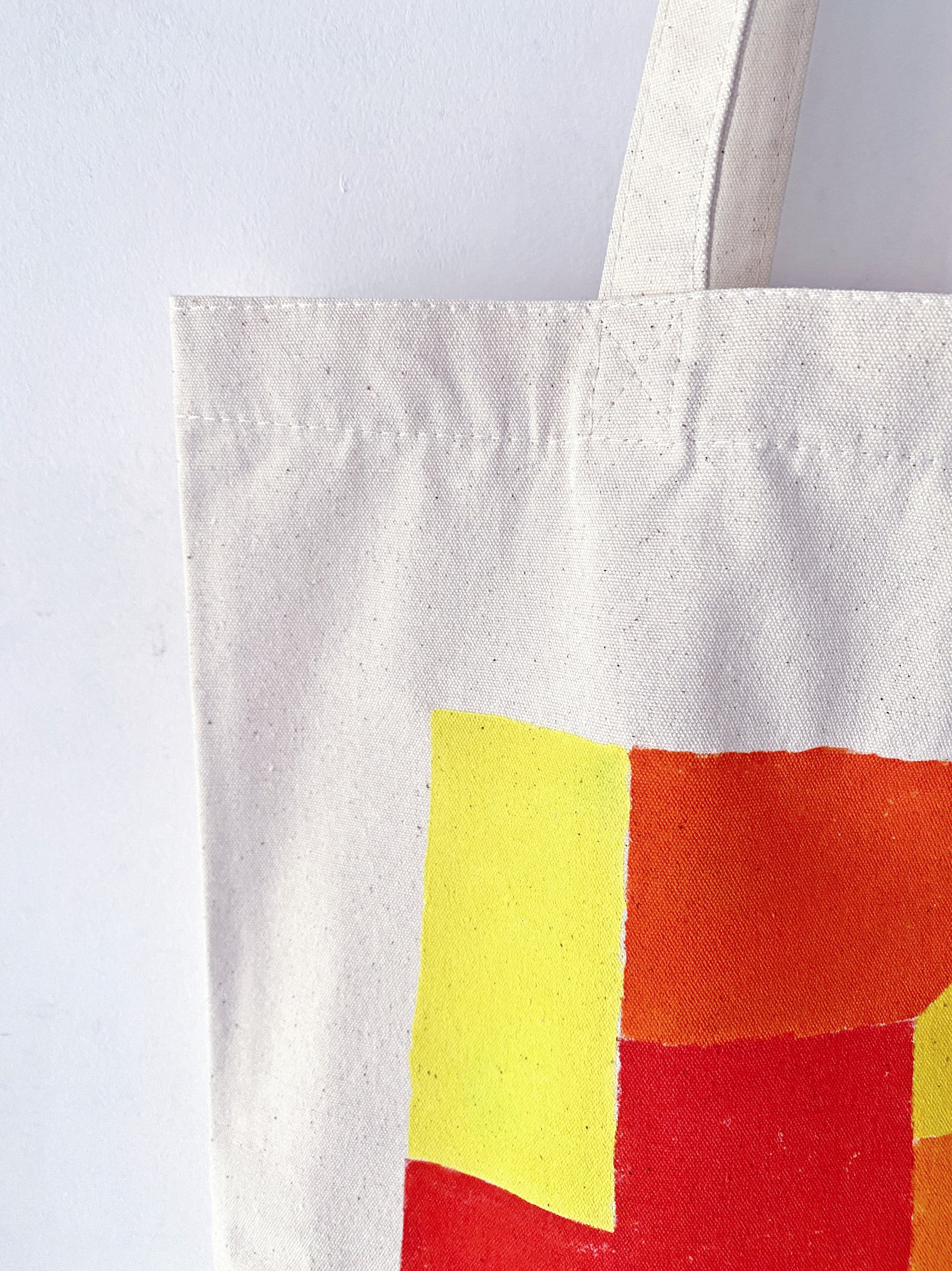 A student using the large canvas bag to carry heavy textbooks and stationery.