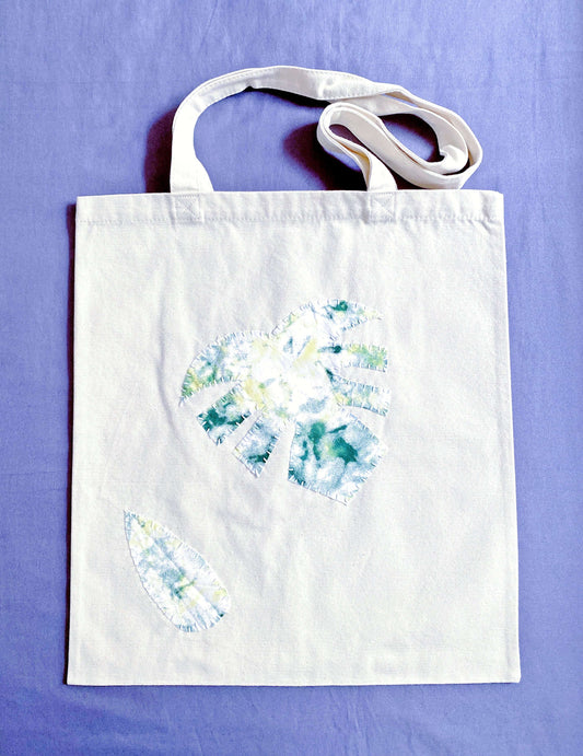 A spacious eco-friendly canvas tote with stitched patchwork, perfect for carrying books during a sunny afternoon walk in Berlin.