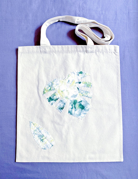 A spacious eco-friendly canvas tote with stitched patchwork, perfect for carrying books during a sunny afternoon walk in Berlin.