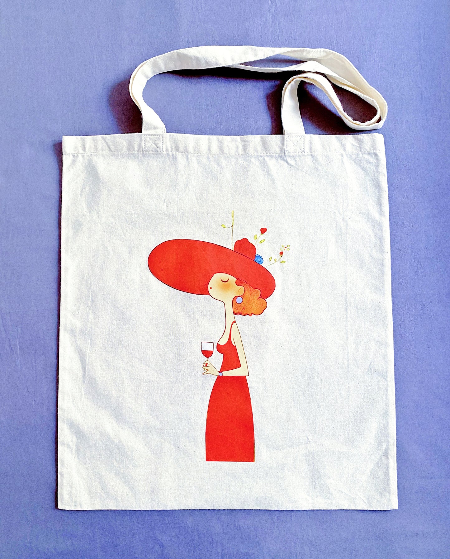 Unbleached cotton tote bag featuring a hand printed woman silhouette resting on a cafe chair.