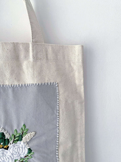 For the friend who has everything but wants nothing plastic; a natural cotton canvas gift that proves utility and high-end embroidery can coexist beautifully.