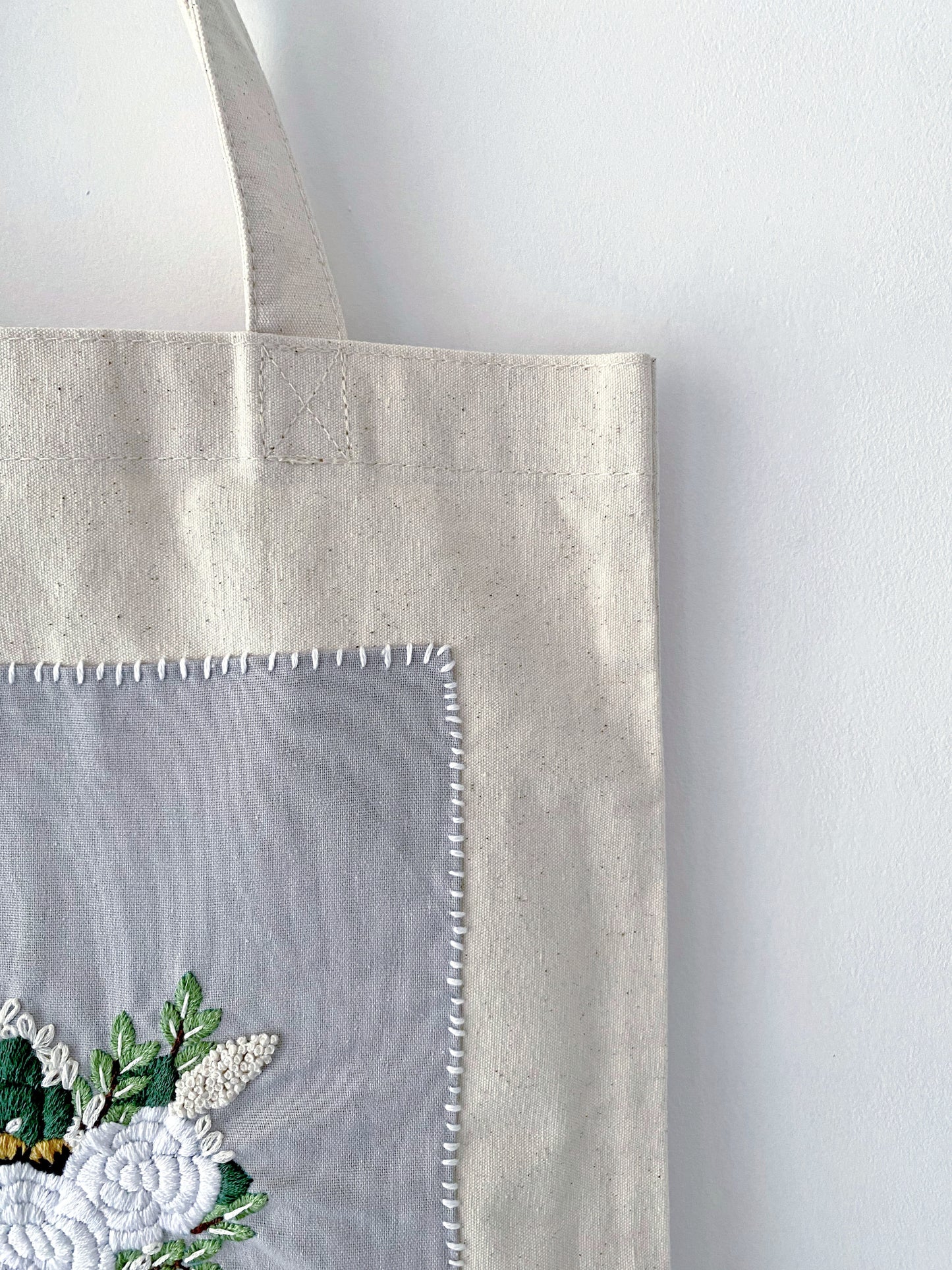For the friend who has everything but wants nothing plastic; a natural cotton canvas gift that proves utility and high-end embroidery can coexist beautifully.