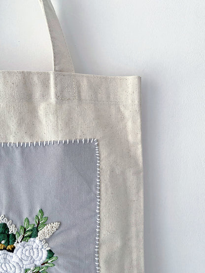 For the friend who has everything but wants nothing plastic; a natural cotton canvas gift that proves utility and high-end embroidery can coexist beautifully.