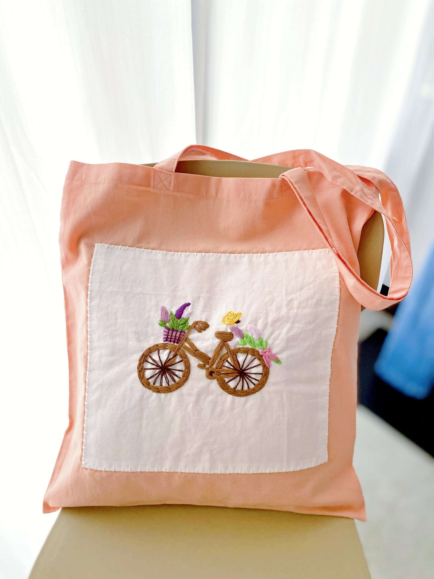 Elevating a messy bun look with this vibrant orange hand embroidered bag that makes quick errands feel stylish.