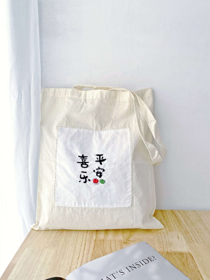 Essentials for slow living packed in a roomy soft tote, accented with a Zen-inspired hand-embroidered Chinese font.