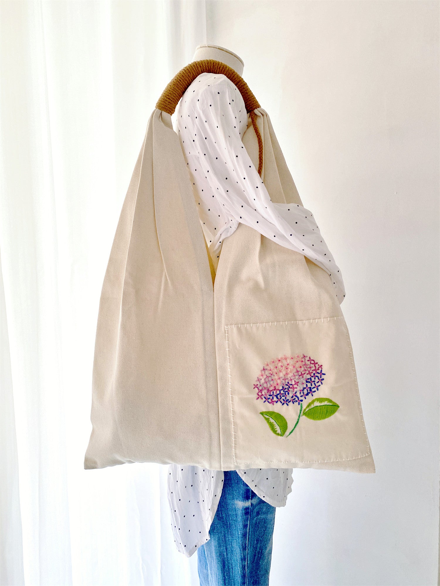 Unique handcrafted floral embroidery on durable canvas tote bag.