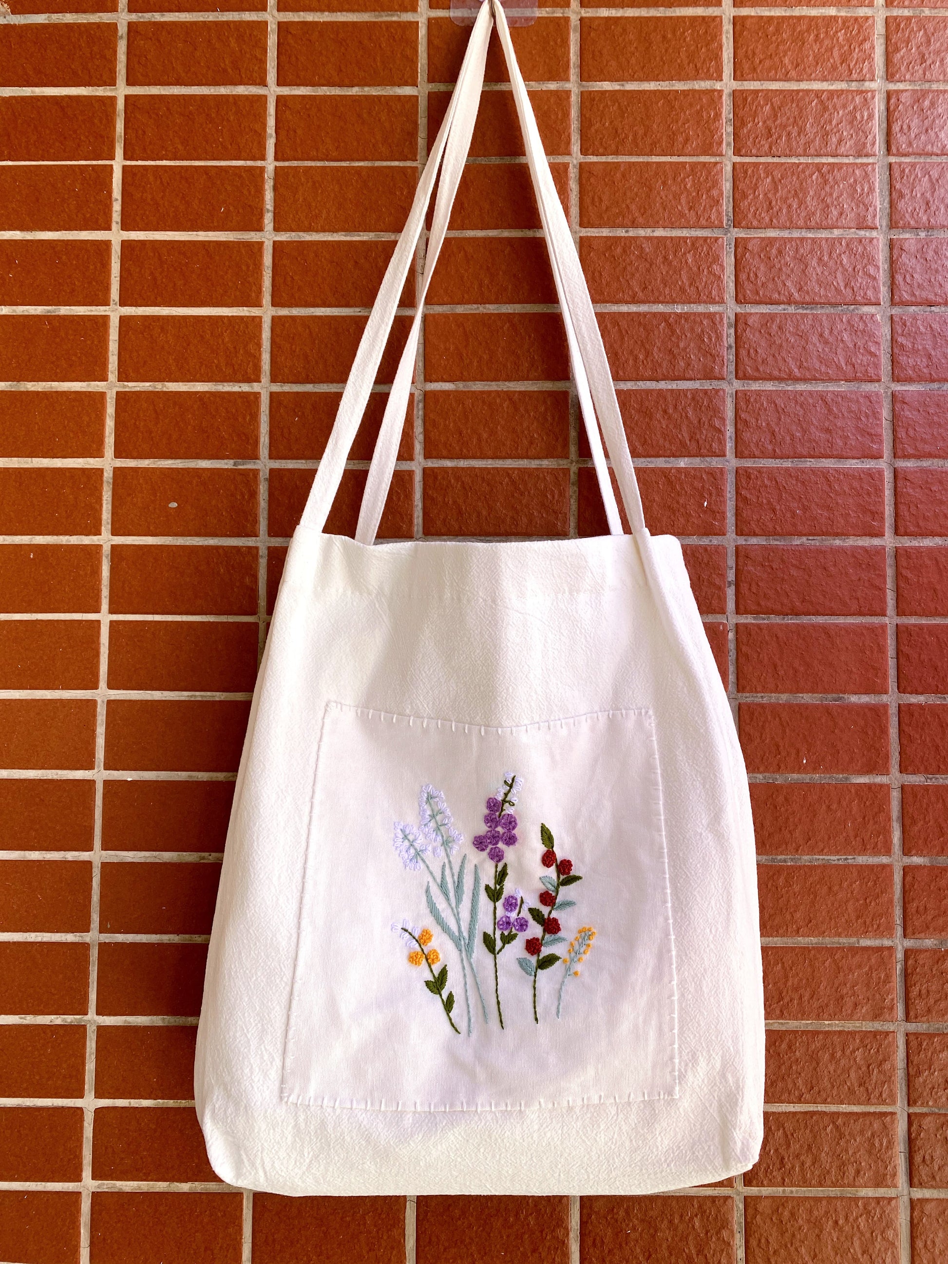 Cotton canvas shoulder bag with handmade floral embroidery for someone beginning retirement