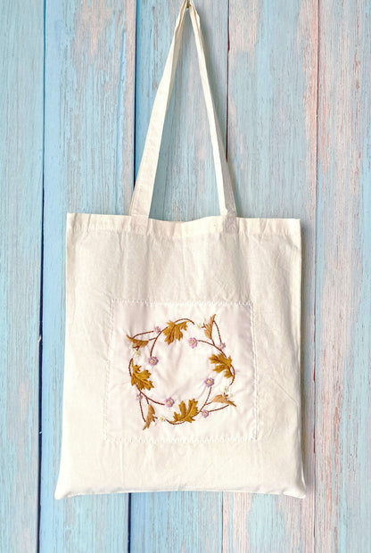 Perfect for the sustainable fashionista, this cotton tote with hand-stitched flowers combines beauty and practicality.
