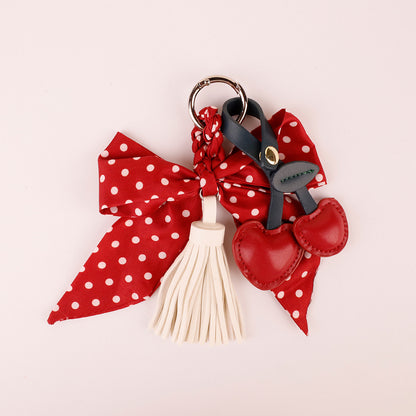 Polka dot bow pendant with dangling tassels on a tote