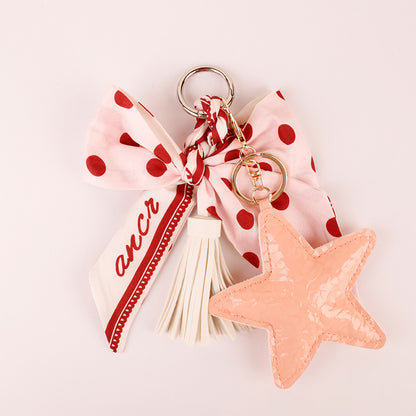Pink handmade bag accessory with bow and tassel details