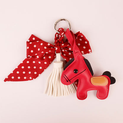 Red decorative keychain with a bow and flowing tassels