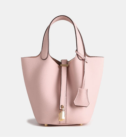 mini leather bucket handbag carried by hand in a modern outfit