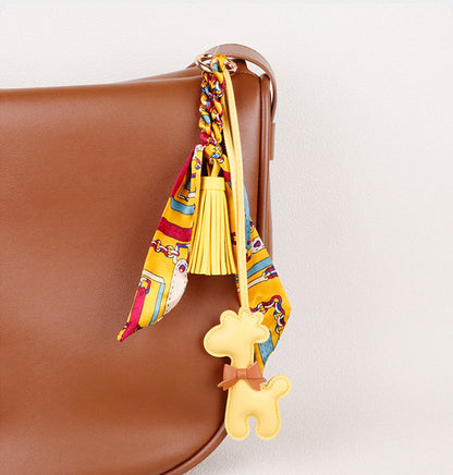 Long flowing scarf and tassel beside a giraffe figure