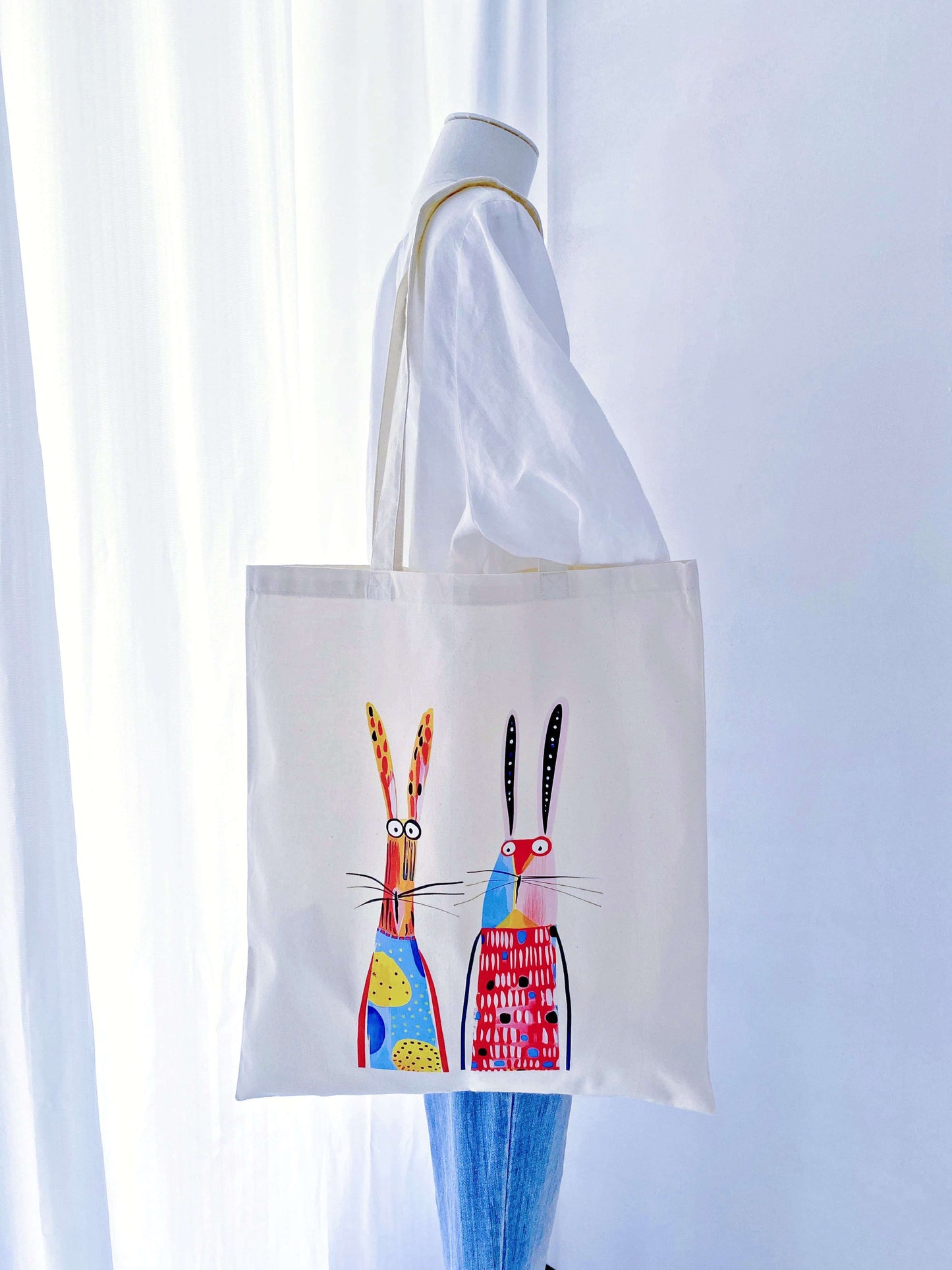 Sunlight filtering through a thin, airy cotton tote with a rabbit print, demonstrating the eco-friendly fabric's natural transparency and lightness.