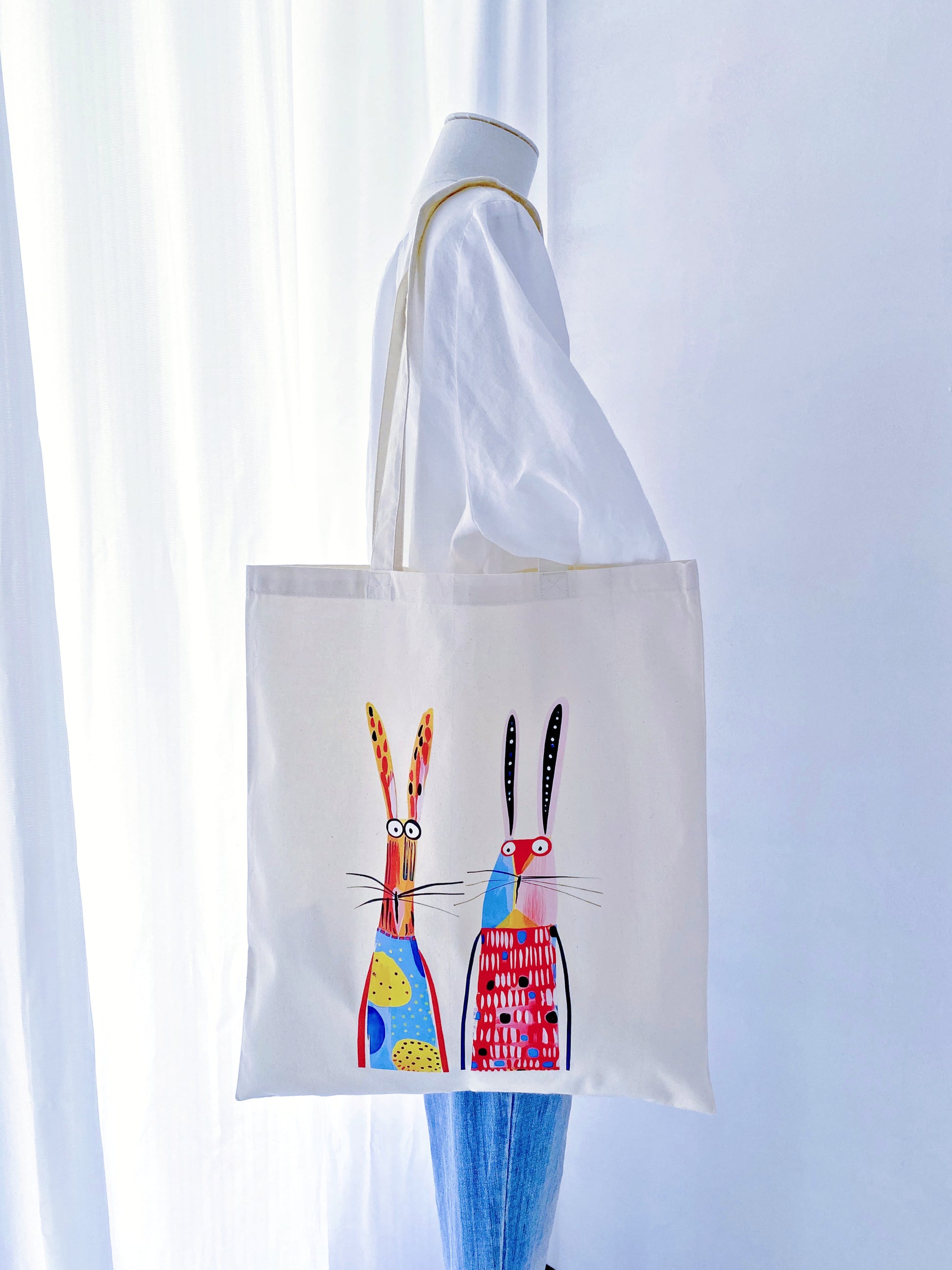 Sunlight filtering through a thin, airy cotton tote with a rabbit print, demonstrating the eco-friendly fabric's natural transparency and lightness.