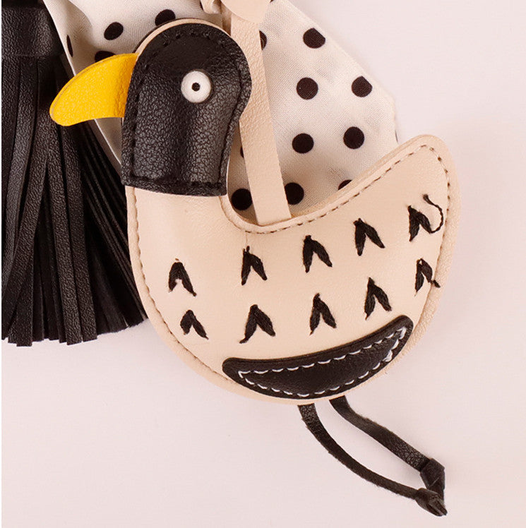 Black and white spotted scarf pendant hanging on a natural canvas bag