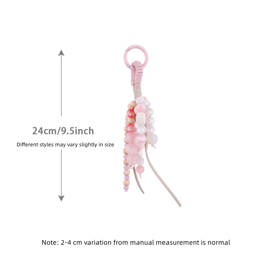 Pink jade charm adding detail to a simple shoulder bag