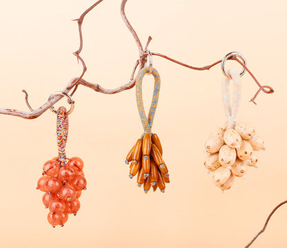 Tiny bell hanging beneath a grape-inspired ornament