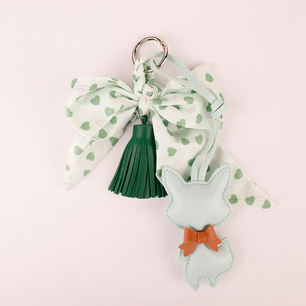 Green scarf tassel bag charm clipped to a canvas work tote