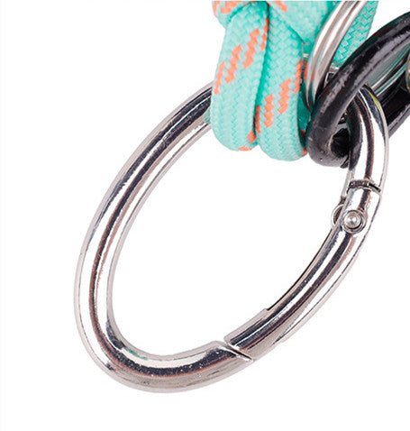 Green handmade charm clipped onto a travel backpack