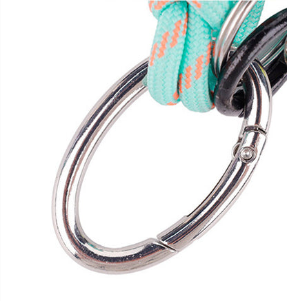 Green handmade charm clipped onto a travel backpack