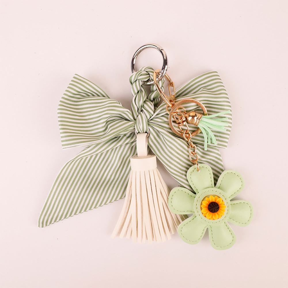 Delicate green bow charm with tassel on a daily commute tote