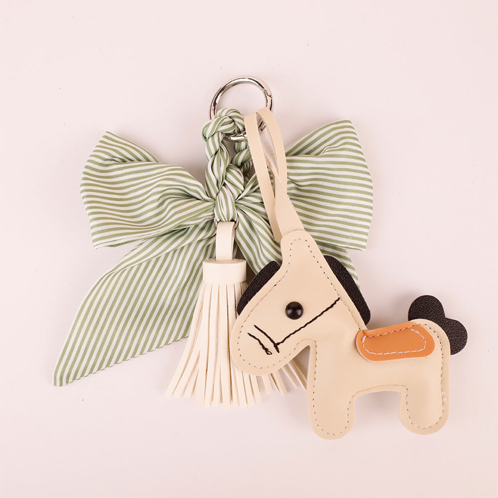Green silk style ribbon accessory tied to zipper pull of purse