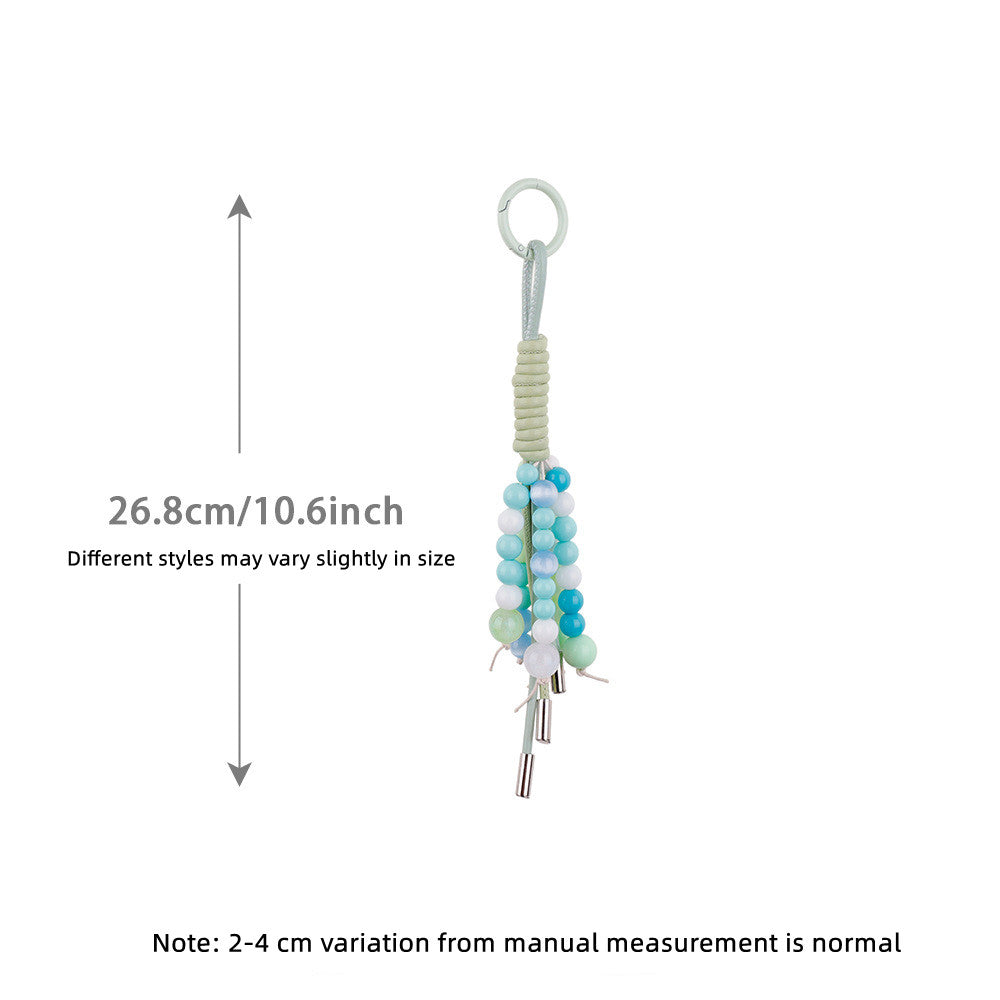 Green braided charm clipped onto a casual backpack