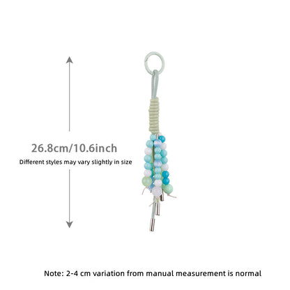 Green braided charm clipped onto a casual backpack