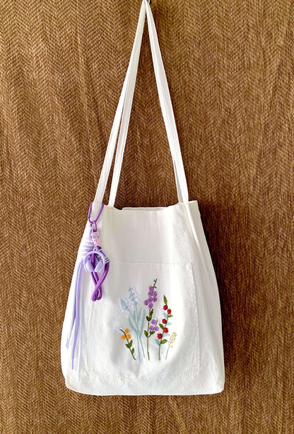 Thoughtful gift for her featuring a hand-embroidered floral linen bag symbolizing slow beauty.
