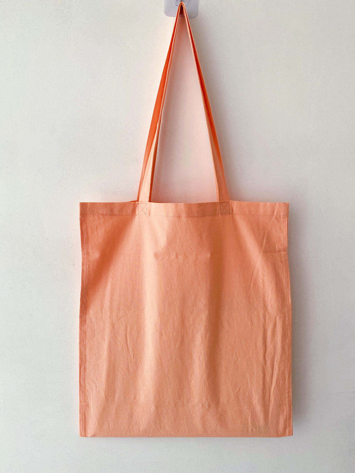 Orange cotton tote with hand-embroidered design chosen as a present for a close friend