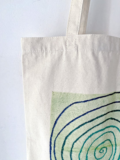 Effortless urban styling with a large fabric bag slung over a chunky knit sweater.