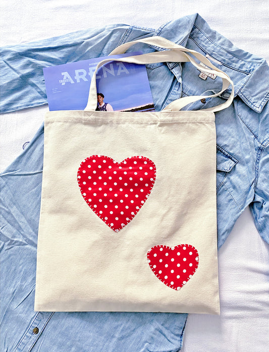 Close-up of artisan hand-stitched patterns on a durable cream canvas shoulder bag.