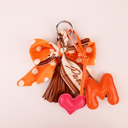 Small orange bow accessory for handbags and everyday bags