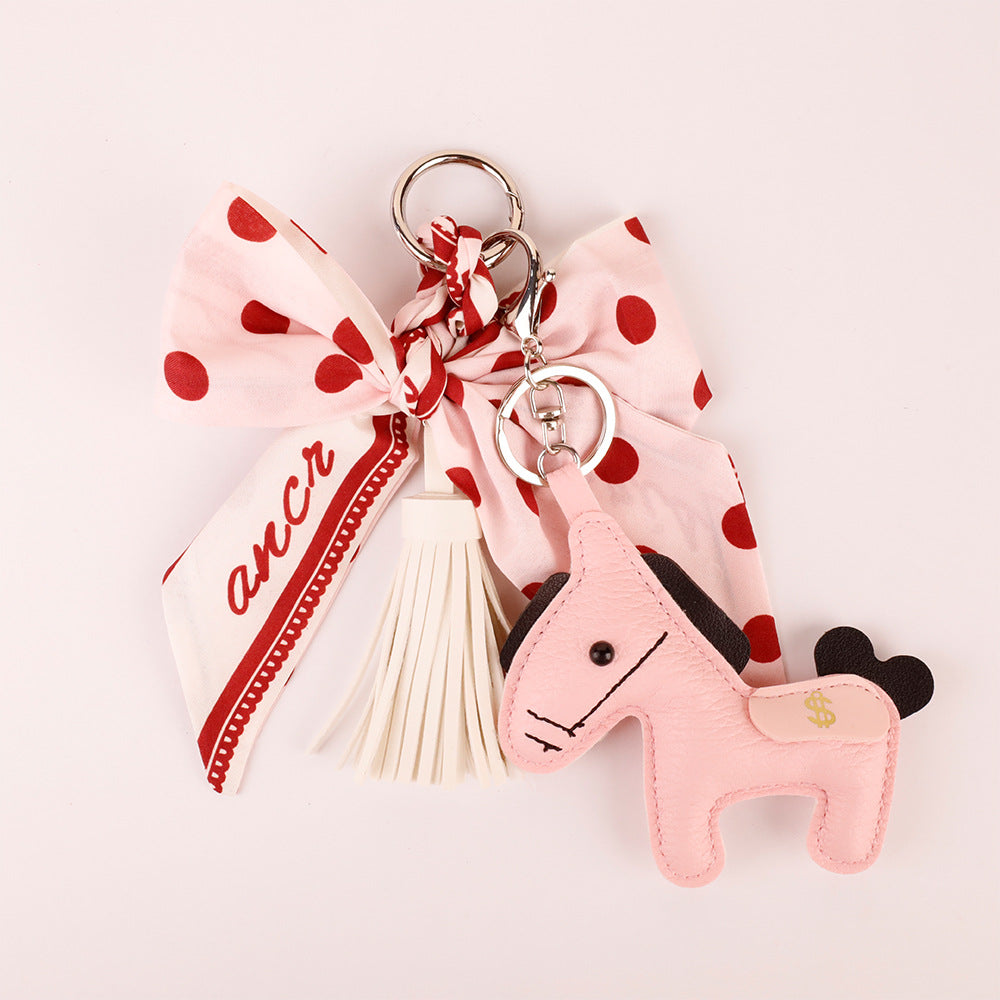 Pink fabric bow charm with dangling decorative pieces