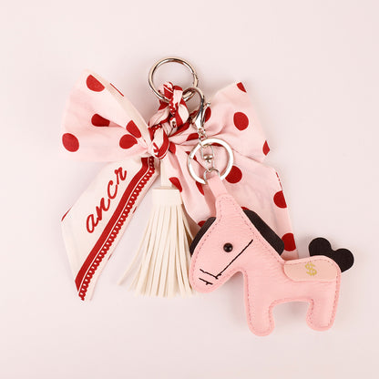 Pink fabric bow charm with dangling decorative pieces