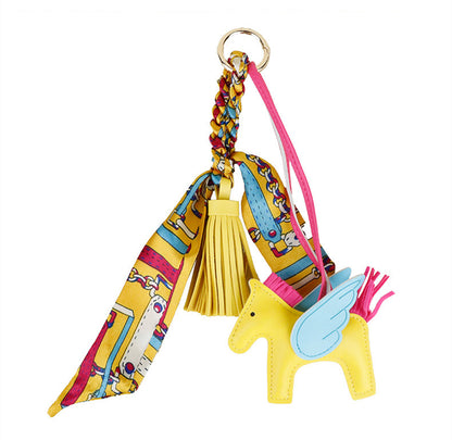Artisanal horse bag charm in rich saddle brown leather paired with gold hardware accents